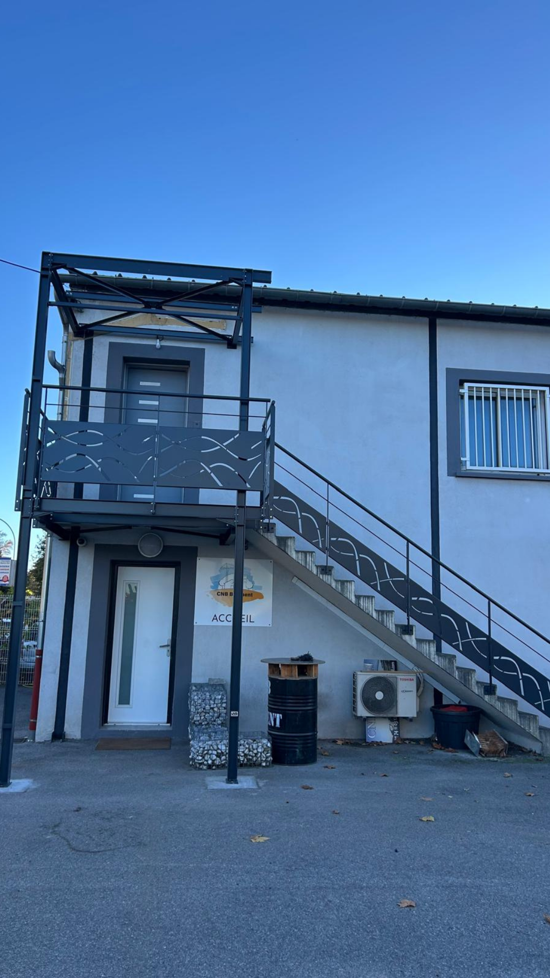 Escalier ext&eacute;rieur en m&eacute;tal avec garde-corps d&eacute;coratif et palier d&rsquo;acc&egrave;s r&eacute;alis&eacute; sur mesure par Metablok