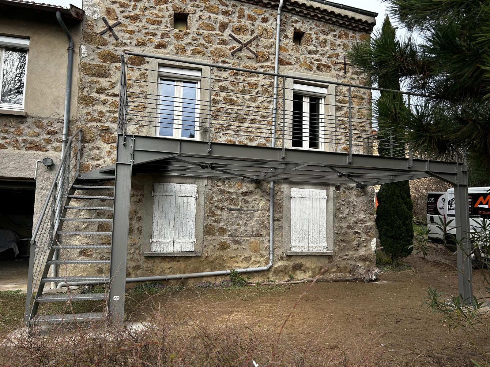 Escalier ext&eacute;rieur en acier avec terrasse suspendue et garde-corps sur mesure