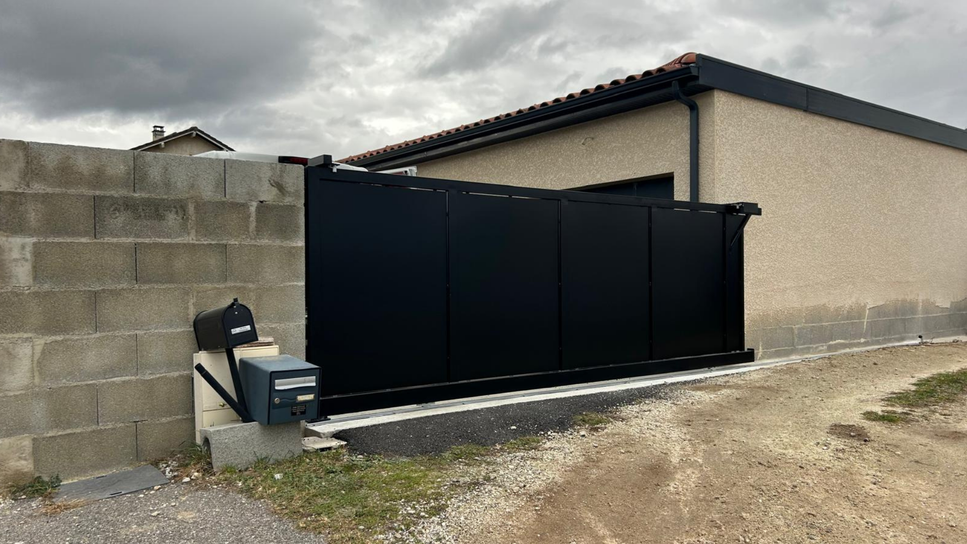 Portail coulissant en m&eacute;tal noir sur mesure install&eacute; sur entr&eacute;e de maison