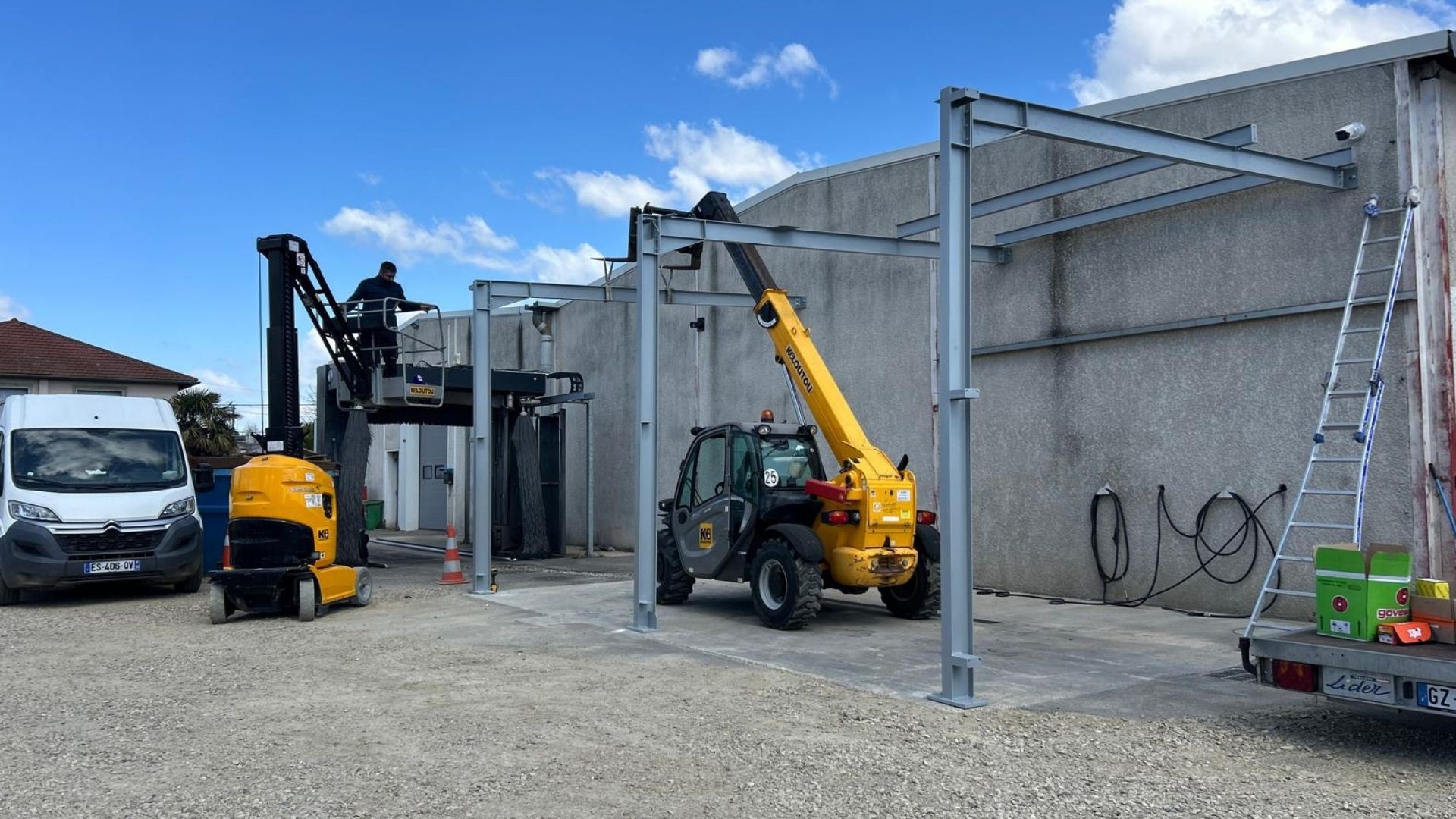 Montage de la charpente m&eacute;tallique sur mesure avec engins de levage pour un abri de station de lavage