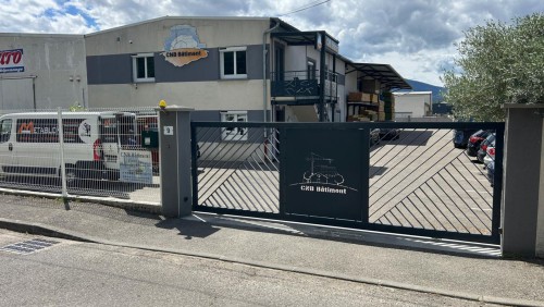 Portail coulissant métallique noir personnalisé avec le logo de CNB Bâtiment à Saint-Maurice-l’Exil